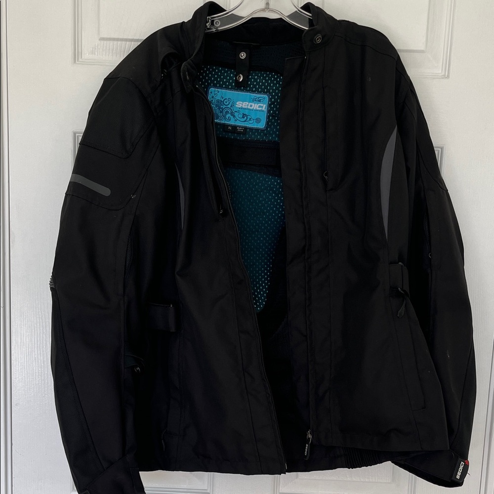 Black Sedici brand women’s protective motorcycle touring jacket with two liners.
